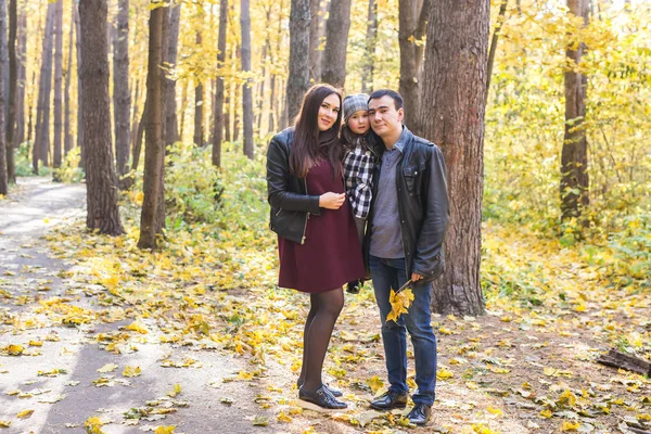 Családi, ősszel, emberek koncepció - fiatal család őszi nap, átölelve és mosoly park séta — Stock Fotó