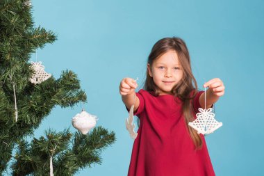 Noel, çocukluk ve insanlar kavramı - küçük kız Noel ağacı süsleme