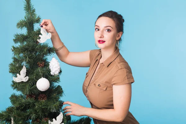 Άνθρωποι, τις διακοπές και τα Χριστούγεννα έννοια - γυναίκα διακόσμηση του Χριστουγεννιάτικου δέντρου σε μπλε φόντο — Φωτογραφία Αρχείου