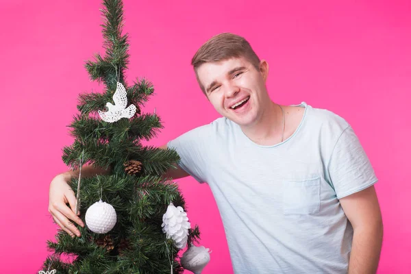 Conceito de feriados e pessoas - Homem feliz com árvore de Natal em fundo rosa — Fotografia de Stock