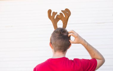 Noel, tatil ve insanlar kavramı - bir geyik boynuzları ile baş mans. Adam başını çizikler