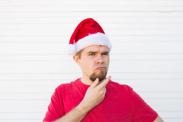 Navidad, la gente, el concepto de las emociones - santa insatisfecha en el sombrero de Navidad — Foto de Stock