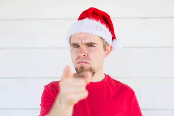 Navidad, la gente, el concepto de las emociones - Papá Noel enojado insatisfecho en el sombrero de Navidad que apunta al espectador — Foto de Stock