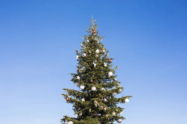 Grande árvore de Natal festivo contra o céu azul — Fotografia de Stock