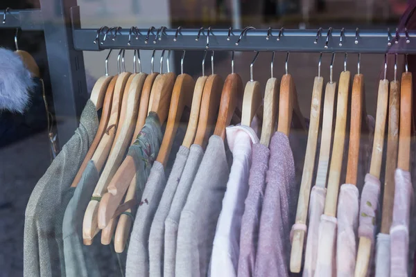 Auswahl an Kleidungsstücken in verschiedenen Farben auf Holzbügeln — Stockfoto