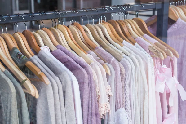 Elección de ropa de moda de diferentes colores en perchas de madera — Foto de Stock