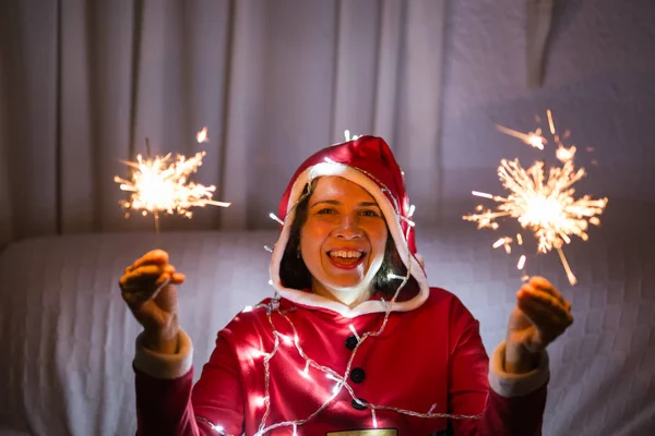 Рождество, праздники и люди концепция - молодая счастливая женщина смеется в рождественском костюме с огнями на белом фоне — стоковое фото