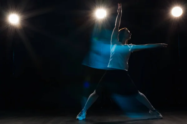 Baile, deporte, hermoso y concepto de la gente - mujer joven bailando en la oscuridad saltó en la luz colorida — Foto de Stock