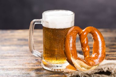 Bardak soğuk soluk bira rustik ahşap bir masa üzerinde çubuk kraker ile