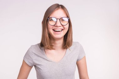 Duygu ve insanlar kavramı - beyaz arka plan üzerinde gülümseyen gözlüklü genç mutlu kadın
