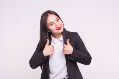 Kırmızı dudaklar ve başparmak yukarıya kopya alanı ile beyaz arka plan ile mutlu esmer Asyalı kadın