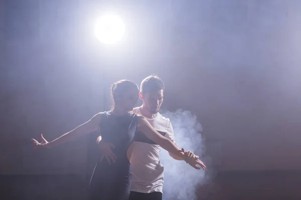 Pareja joven bailando baile latino Bachata, merengue, salsa. Dos poses de elegancia en clase de baile — Foto de Stock