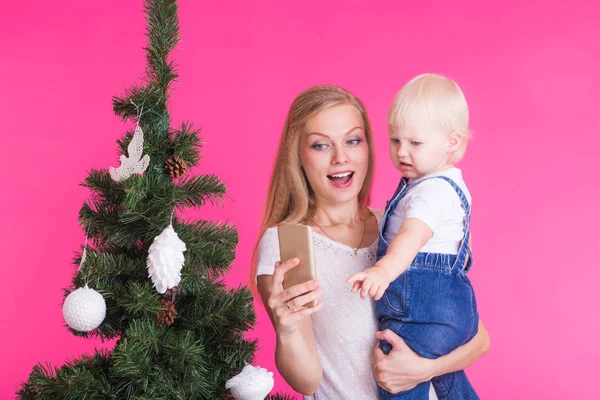 Η μητέρα και η μικρή κόρη λαμβάνοντας μια selfie κοντά στο χριστουγεννιάτικο δέντρο — Φωτογραφία Αρχείου