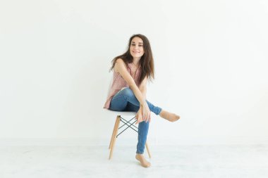 Beyaz arka plan kopya alanı ile bir sandalyede oturan güzel kız öğrenci