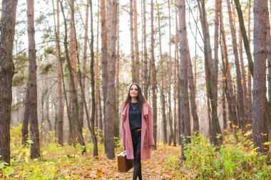 İnsanlar, sezon ve doğa kavramı - sonbahar parkta yürüyen genç kadın