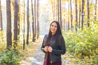 Sonbahar, mevsim ve insanlar kavramı - sonbahar parkta duran genç esmer kadın