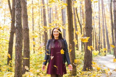 Komik kadın yaprakları sonbahar parkta atma