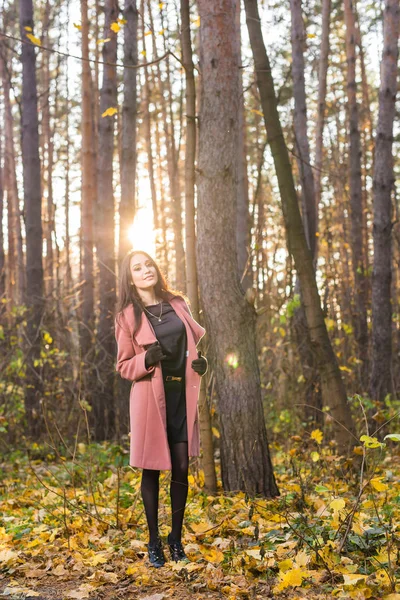 秋天, 自然和人概念-粉红色大衣在公园散步的年轻黑发妇女 — 图库照片
