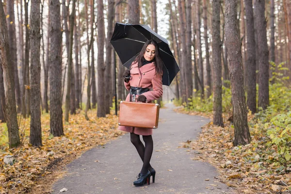 Mensen, seizoen en fashion concept - mooie jonge vrouw in herfst park met paraplu — Stockfoto