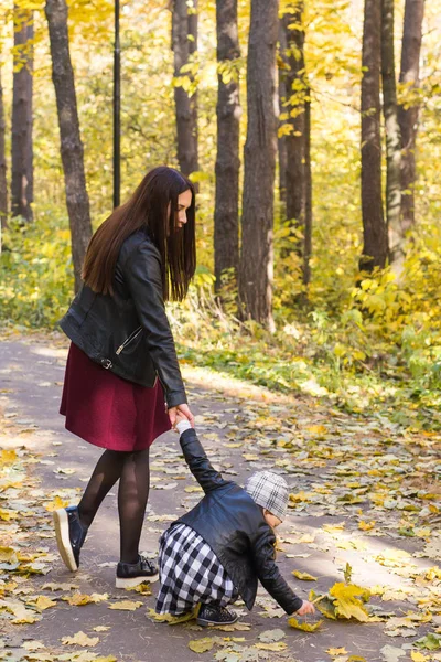 Conceito de outono, natureza e família - Mãe e seu filho caminhando no parque — Fotografia de Stock