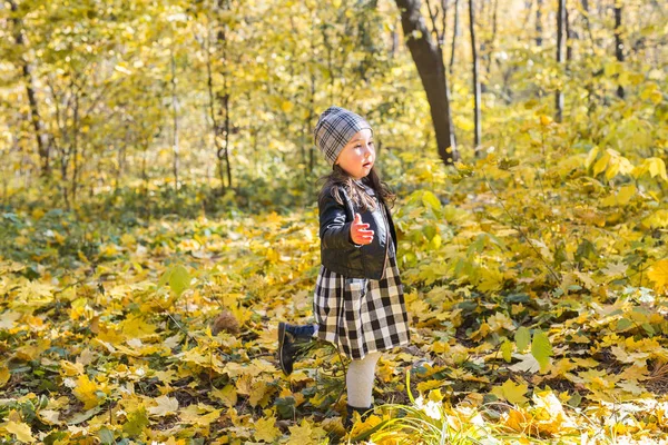 Familia, niños y concepto de temporada - niña feliz caminando en el parque de otoño —  Fotos de Stock