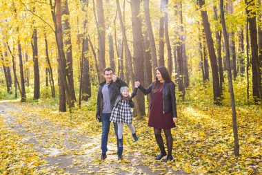 Kişi, Aile ve eğlence kavramı - karışık yarış babası ve annesi kızları ile Sonbahar Park eğlence var