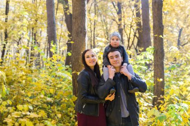 Kişi, Aile ve eğlence kavramı - mutlu baba küçük kızı sonbahar park ve ana sırtına holding