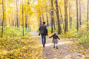 Aile, sonbahar, insanlar kavramı - baba ve kız sonbahar Park'ta yürüyordunuz