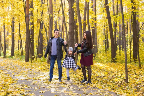 Rodzicielstwa, upadku i ludzi pojęcie - młoda rodzina szczęśliwy w jesienny park — Zdjęcie stockowe