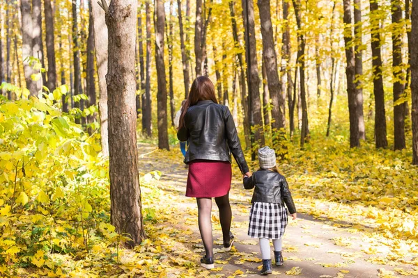 Personer, familj och fritid koncept - ung mamma promenader med sin dotter i höst park — Stockfoto