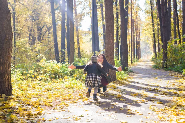 Gelukkige familie concept - moeder en kind dochtertje spelen in de herfst natuur — Stockfoto