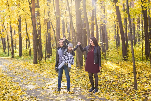 Famiglia, autunno, concetto di persone - giovani famiglie che camminano nel parco in autunno — Foto Stock