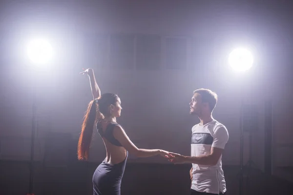 Pareja joven bailando baile latino Bachata, merengue, salsa. Dos poses de elegancia en clase de baile — Foto de Stock