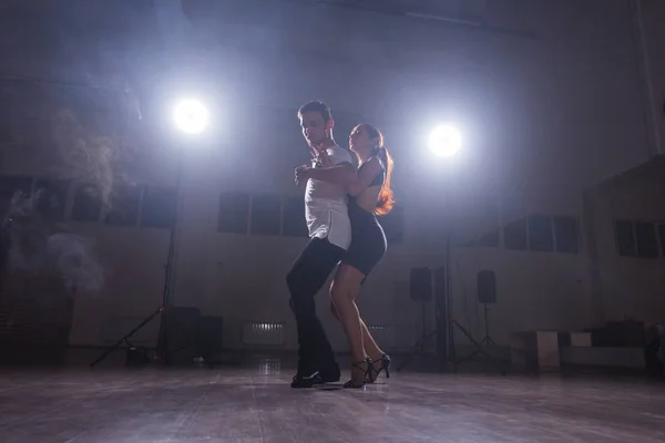 Pareja joven bailando baile latino Bachata, merengue, salsa. Dos poses de elegancia en clase de baile — Foto de Stock