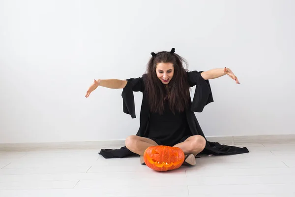 Koncepcja Halloween i maskarady - piękna młoda kobieta stwarzających z dyni Jack-o-lantern. — Zdjęcie stockowe