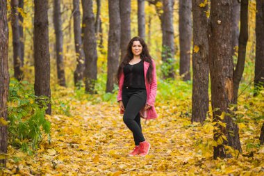 Sonbahar, mevsim ve insanlar kavramı - genç kadın parkta sonbahar poz