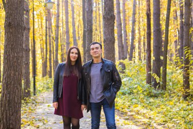 Kişi, Aile ve eğlence kavramı - sonbahar Park'ta yürüyordunuz genç çift