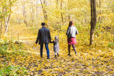 Sonbahar, Doğa ve Aile kavramı - aile sonbahar Park'ta yürüyordunuz arkadan görünüm