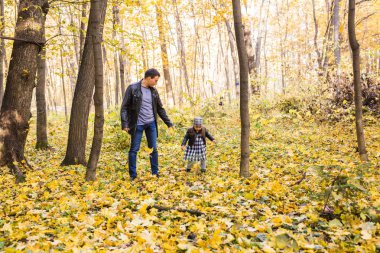 Aile, sonbahar, insanlar kavramı - baba ve kız sonbahar Park'ta yürüyordunuz