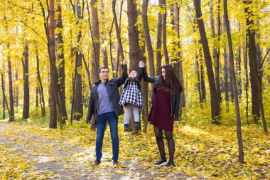 İnsanlar, Aile ve eğlence kavramı - Anne, baba ve küçük kız içinde sonbahar park eğlenmek