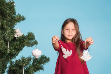 Noel, çocukluk ve insanlar kavramı - küçük kız Noel ağacı süsleme.