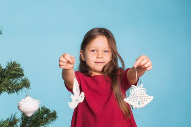 Noel, çocukluk ve insanlar kavramı - küçük kız Noel ağacı süsleme