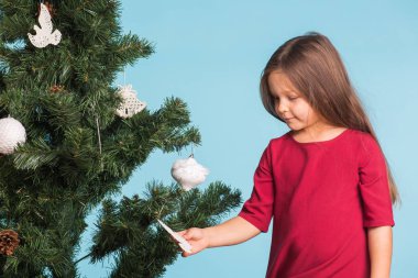 Noel, çocukluk ve insanlar kavramı - küçük kız Noel ağacı süsleme