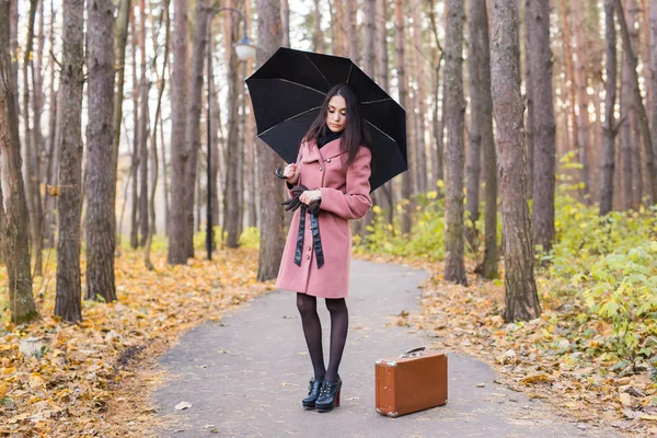 Pessoas, estação e conceito de moda - bela jovem no parque de outono com guarda-chuva — Fotografia de Stock