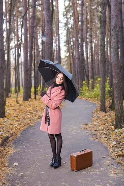 Temporada, diversão e conceito de pessoas - Mulher atraente no parque de outono posando com guarda-chuva — Fotografia de Stock