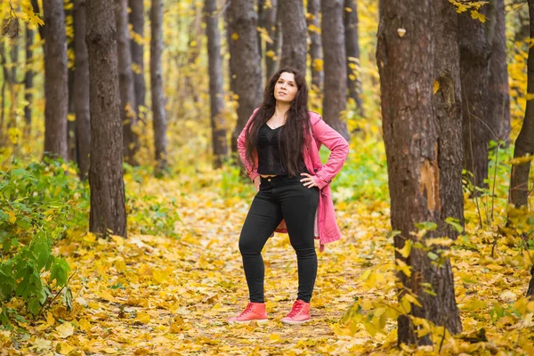 Autumn, nature and people concept - Retrato de mujer de talla grande en chaqueta rosa en el parque —  Fotos de Stock