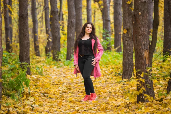 Pogoda, sezon, koncepcja ludzie - plus rozmiar Kobieta w różowy płaszczyk na jesień natura tło — Zdjęcie stockowe