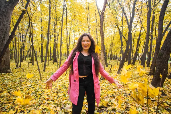 Joven mujer divertida lanzando hojas en el parque de otoño — Foto de Stock
