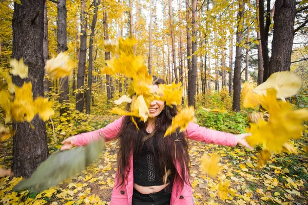 Herbst, Freude und Menschen Konzept - junge Frau hat Spaß im Herbst Park. sie wirft gelbe Blätter in den Himmel — Stockfoto
