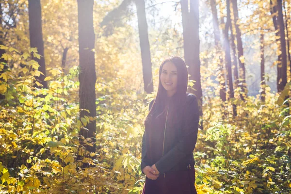 Portret van een mooie jonge vrouw die in de herfst buiten loopt. — Stockfoto